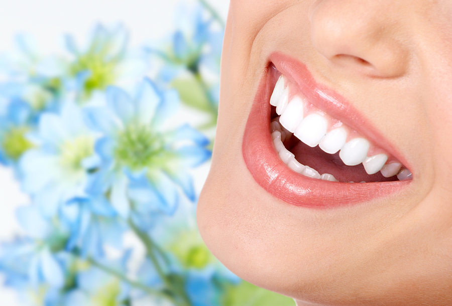 blue flower background, foreground is close up of woman's mouth white teeth, Cosmetic Dentistry Narberth, PA dentist