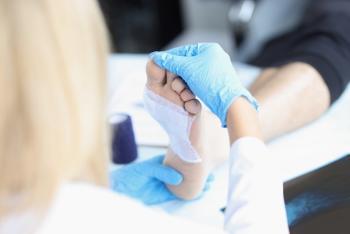 Podiatrist performing wound care on patient's foot