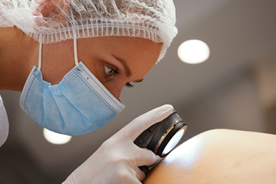 Dermatologist examining patient’s skin for conditions or abnormalities