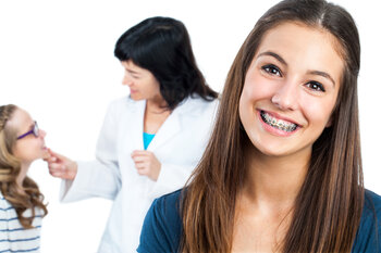 girl smiling with braces with Orthodontist in background with young female patient, braces in Des Plaines, IL