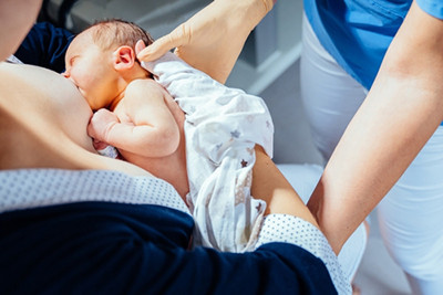 Mother with her newborn receiving lactation support