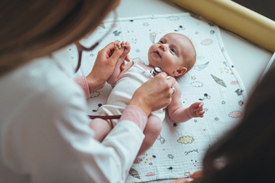 Pediatrician examining newborn baby during checkup