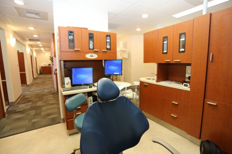 photo of our new office aiea pearl city dental care built in 2013 photo of hallway and a dental room with chair and two computer screens and new cabinetry