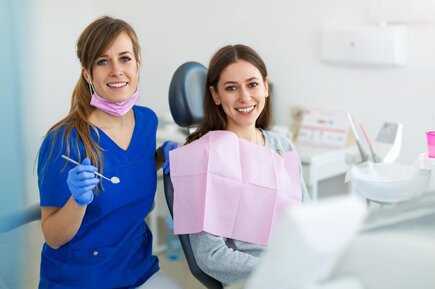 dental hygienist examining female patient in dental exam chair, general dentistry Mt Airy, NC dentist