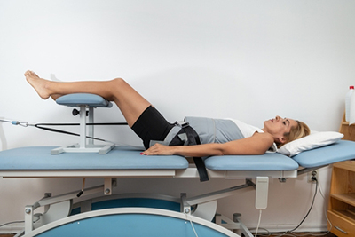 Woman lying on spinal decompression table during therapy session